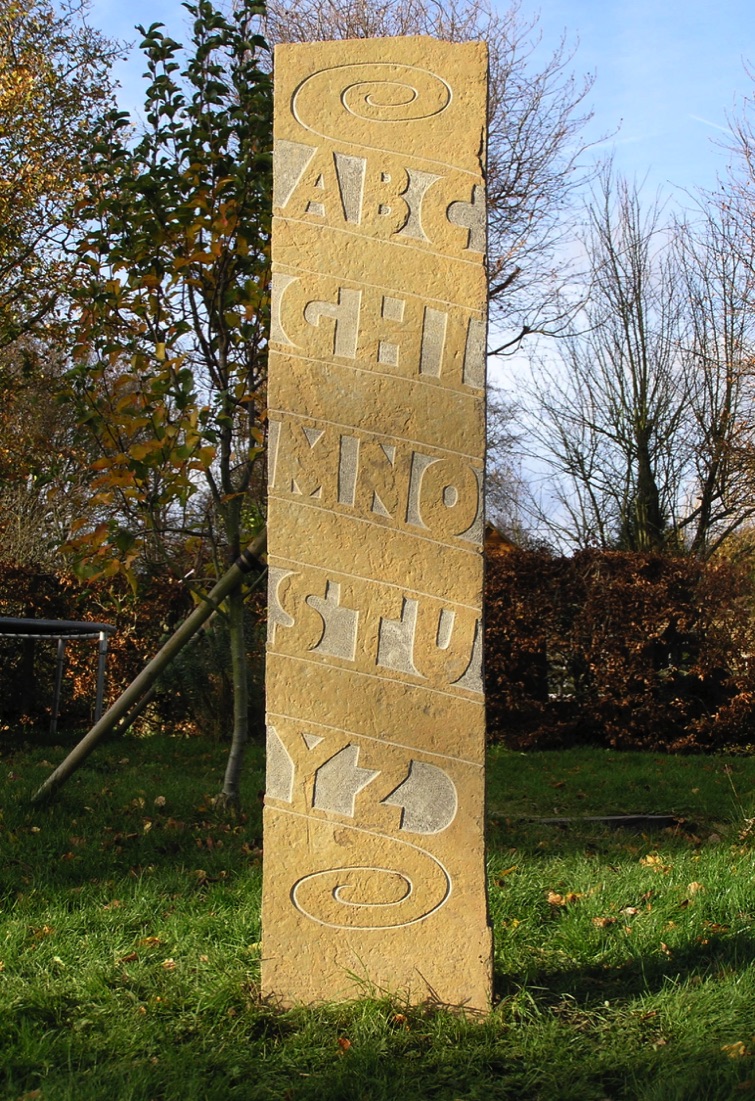 standing stone with raised block form alphabet letters